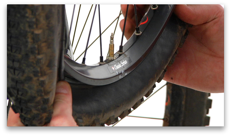2:48 mark - Keeping the wheel in the same position (valve stem at 6 o'clock), use both hands to install the bead evenly around the tire, finishing at the 12 o'clock position