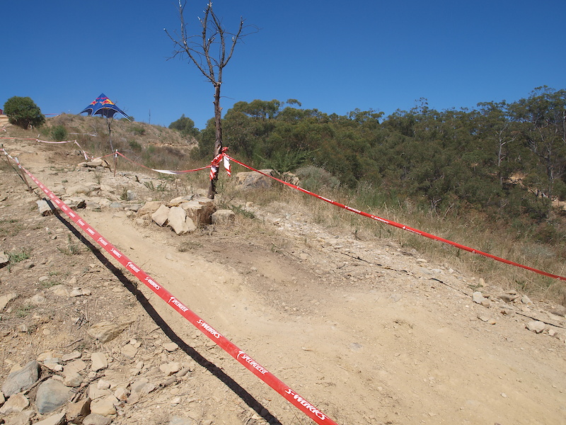 As riders head down the ridge they are greeted by various rock gardens and whoops. Here in this photo, the fast riders coming from the left will gap off these rocks and land some 3-4m past on the down side of the visible whoop.
