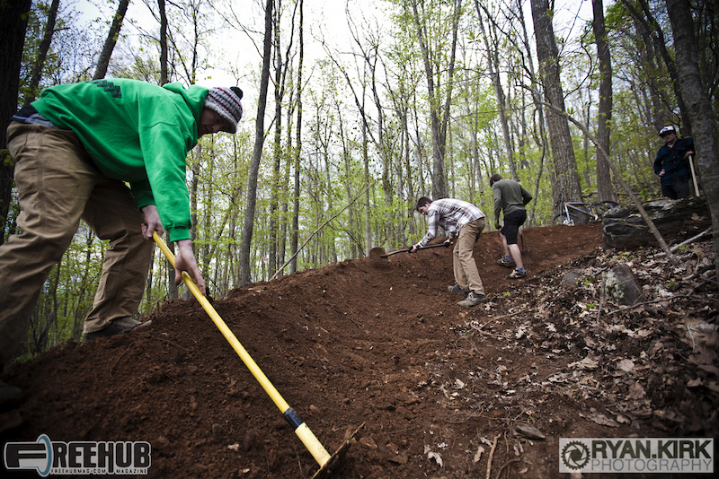 Rowan and local volunteers shaping a new berm at Rocky Knob Mtn Bike Park