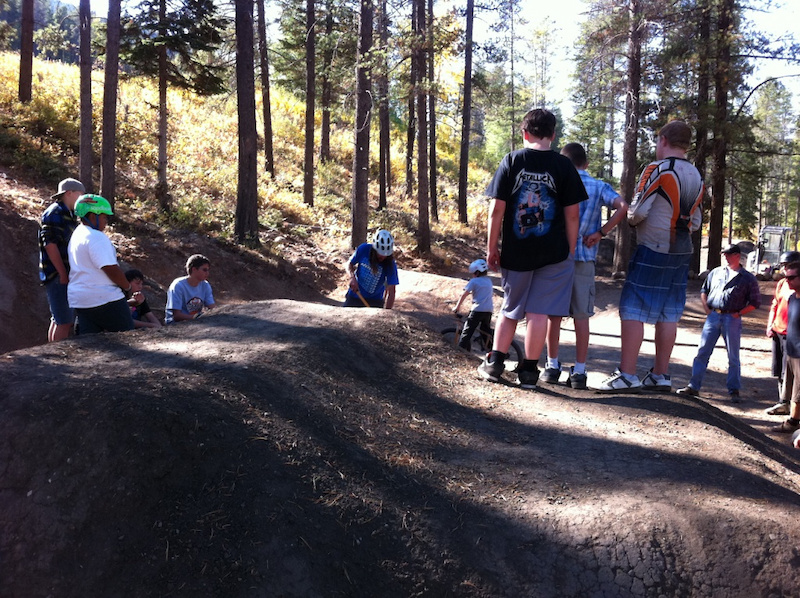 Jay Hoots with a very captive audience of local kids getting tips on how to maintain and shape the dirt jumps at their new bike skills park in Crowsnest Pass.