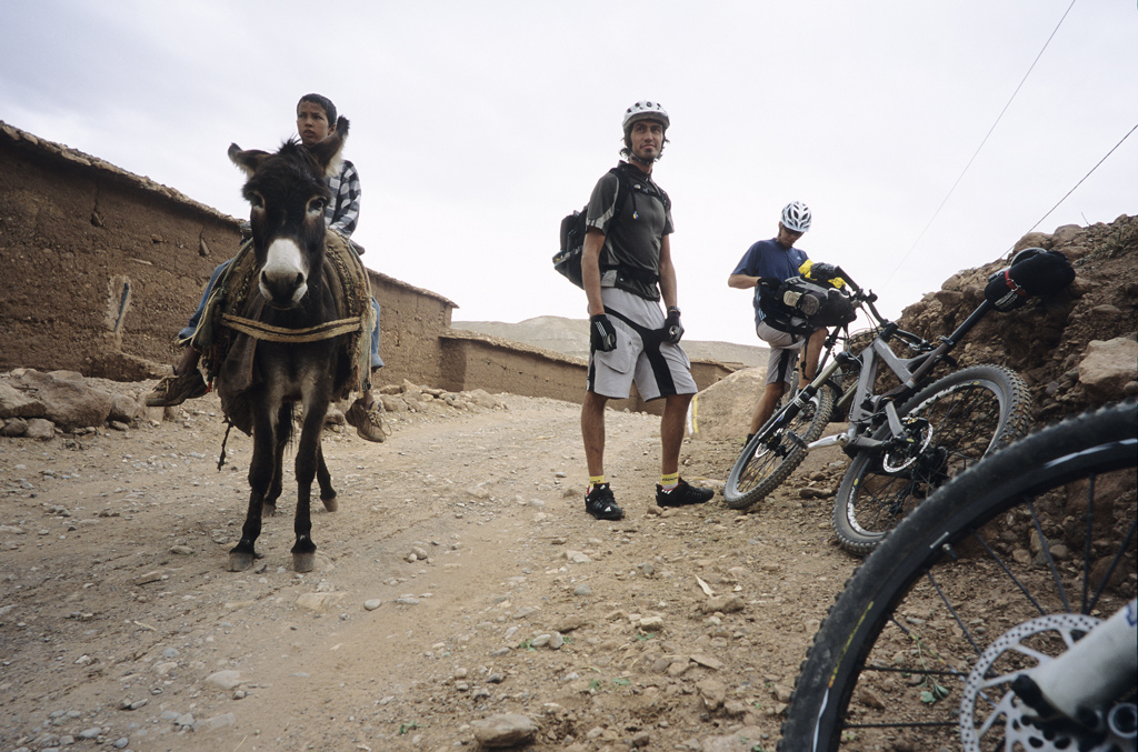 <span style='font-size:12px'>On day two we stumbled across this lad with his donkey. In pigeon French he managed to try to barter a swap, the donkey for a bike. We were tempted, but weren't sure how his father would be if he returned without the family's trusty beast of burden.</span><br><br>A recent starring role in the marvelous Roam mountain bike DVD has put Morocco squarely on the mountain bike map. The country, with its rugged mountain ranges and alien culture, is a one stop shop for adventure and serious riding possibilities and is accessed by a sub four hour flight from the UK. An Anglophile French friend and Chamonix riding pal, Guillaume, has ridden through Morocco's High Atlas mountains before, meaning that much of mine and Mike's preparation consists of badgering him to tell us what to expect. As we paw over maps, he fields our questions with ambiguous answers. 'We can try this way, but maybe we won't get through' he mumbles, tracing a finger along a dotted line. It is clear that although Guillaume has an idea for a route across, down, round and back over the Atlas mountains, a lot will be down to chance, or as I soon learn, 'Inshallah' (the will of God). Riding 4x4 tracks and sniffing out singletrack wherever we can find it, our XC trip will be a million miles from the freeride jaunt that appears in Roam, but we have a plan at least.