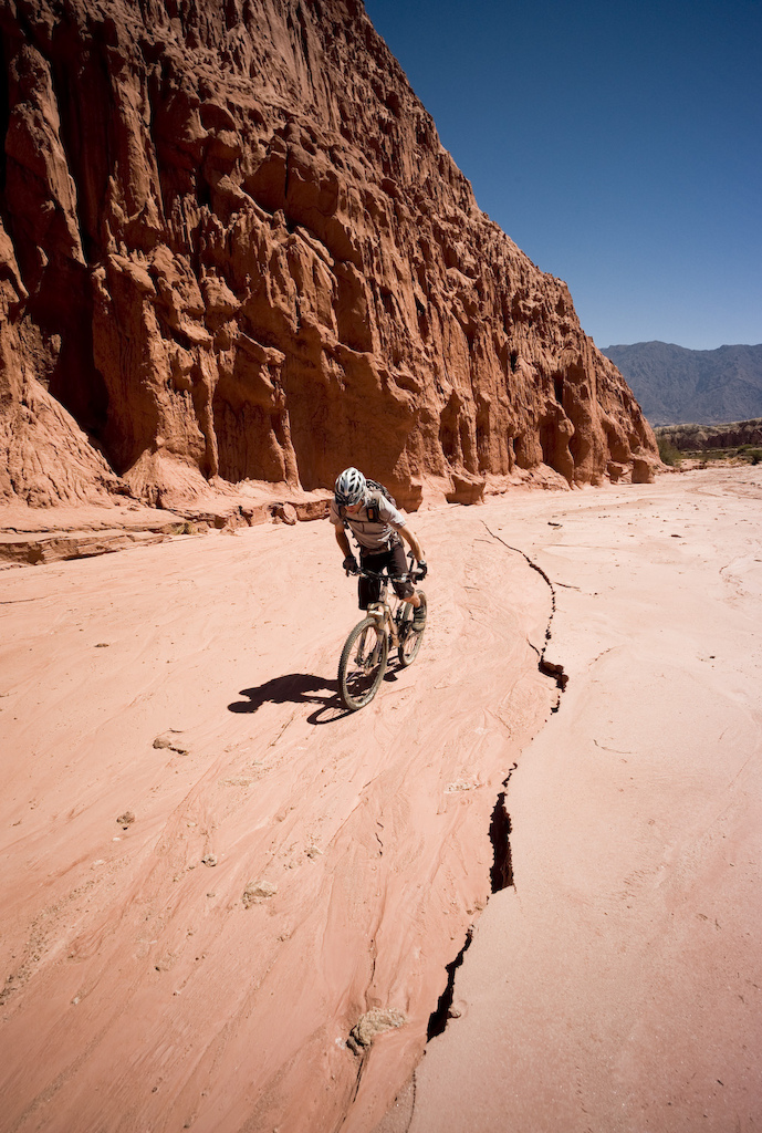 <span style='font-size:12px'>Singletrack trails remained elusive around the town of El Cafayate, but we found great riding by following the dry river beds instead, riding the concrete-hard, rolling river beds as out-and-backs, climbing kilometers up into the hills between magnificent rock features.</span><br><br>The 'trail' turns out to be a dry riverbed that disappears from view between two enormous rock towers that stand like immense gates at the entrance to another world. It's not what we were expecting, but lacking any other trail to ride we decide to give it a go and take off between the enormous rocks. All along the highway are rock formations signposted and labeled so tourists can stop and stare and snap a photo before continuing to the next one a few miles on, but here, hidden on the other side of this huge rock gateway is a world free of tourist paraphernalia. We are alone.